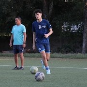 Un joueur de soccer est ballon au pied lors d'un entraînement.