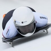 Une athlète est couchée sur le ventre sur son skeleton.