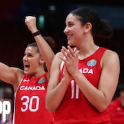 Deux basketteuses canadiennes célèbrent une victoire.