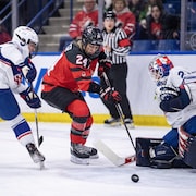 Une hockeyeuse canadienne tente de déjouer une gardienne. américaine.