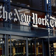 Le logo de la compagnie, une écriture stylisée du nom New York Times, est placé au-dessus des portes d'entrée. 