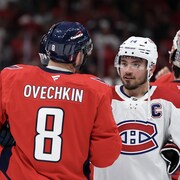Deux joueurs de hockey se serrent la main au centre de la glace à la conclusion d'une série