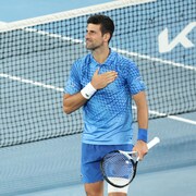 Le joueur de tennis Novak Djokovic pose sa main droite sur son torse.