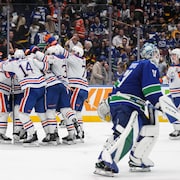 Les joueurs des Oilers entourent Evan Bouchard après qu'il ait inscrit le but gagnant. 
