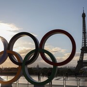 Les anneaux olympiques et, en arrière-plan, la tour Eiffel.