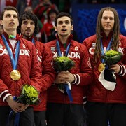 Guillaume Bastille, Charles et François Hamelin, Olivier Jean et François-Louis Tremblay se tiennent debout sur le podium après avoir remporté l'or au relais 5000 m masculin, en patinage de vitesse courte piste, aux Jeux olympiques de Vancouver en 2010.