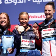 Trois médaillées posent sur le podium.