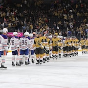 Les joueurs des Oilers et des Golden Knights se donnent la main au centre de la patinoire. 