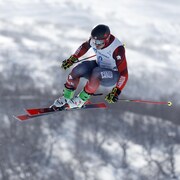 Le spécialiste de ski cross Reece Howden effectue un saut.