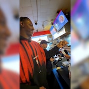 R.J. Barrett commande une poutine au comptoir d'un restaurant lors d'un &eacute;v&eacute;nement promotionnel.