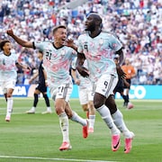 Deux joueurs de soccer célèbrent un but.