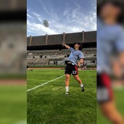 Un joueur lance le frisbee sur un terrain d'ultimate frisbee. 