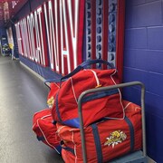 Sac de hockey dans un corridor, devant une inscription lumineuse The wildcat way.