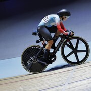 La cycliste canadienne en action sur son vélo aérodynamique spécialisé pour la piste. 