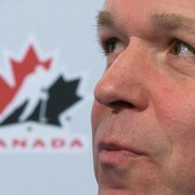 Très gros plan du visage d'un homme. Un logo de Hockey Canada apparaît à l'arrière-plan.