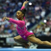Une gymnaste fait sa routine au sol.