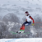 Marielle Thomson, dans les airs, effectue un tournant dans un course de ski cross