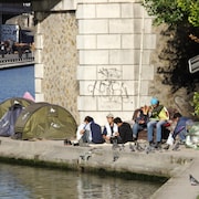 Un groupe de sans-abris sous un pont à Paris.