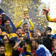 Le gardien français Hugo Lloris (au centre) soulève le trophée de la Coupe du monde à titre de capitaine après la victoire de son pays contre la Croatie.