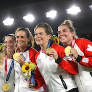 Quatre joueuses montrent leur médaille d'or.