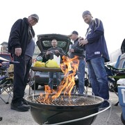 Des partisans se réunissent pour cuisiner et boire un verre avant la joute de leur équipe sportive favorite. 