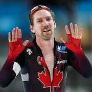 Le patineur Ted-Jan Bloemen lève ses mains en l'air.