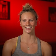 Portrait de l'athlète olympique Summer McIntosh sur fond rouge.