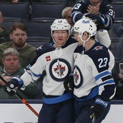 Deux joueurs de hockey se félicitent sur la glace. 