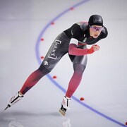 Valerie Maltais en train d'effectuer un virage dans sa course de patinage de vitesse sur 5000 mètres.