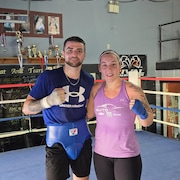 Un boxeur et une boxeuse posent dans le ring.