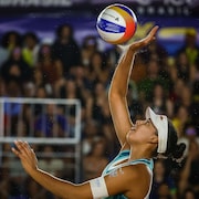 Elle tend la main pour faire une touche au-dessus de sa t&ecirc;te.