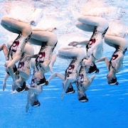 Les nageuses ont la tête en bas sous l'eau.