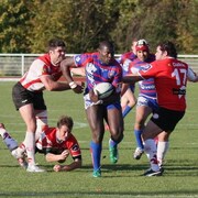 Photo d'une équipe de rugby jouant sur un terrain extérieur.