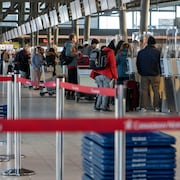 Des voyageurs enregistrent leurs bagages à l'aéroport d'Ottawa. 