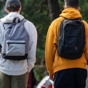 Deux élèves marchent côte à côte avec leurs sacs sur le dos.