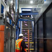 Un convoyeur transporte les sacs mauves dans le centre de récupération des déchets organiques.