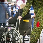 Un militaire pousse un epersonne assise dans une chaise roulante, le 4 janvier 2022.