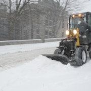 Une déneigeuse enlève la neige dans une rue de Montréal.