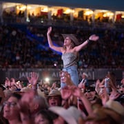 Une fille qui chante et danse les bas dans les airs dans une foule.