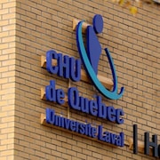 Plan rapproché de l'enseigne du CHU de Québec-Université Laval sur un mur extérieur de l'Hôpital de l'Enfant-Jésus.