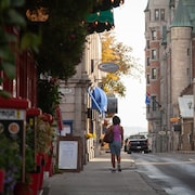 Une touriste se promène sur un trottoir vide du Vieux-Québec.