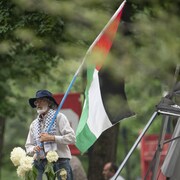 Un homme tient un drapeau palestinien au bout d'un bâton.