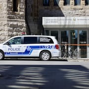 Une voiture de police est stationnée devant le Musée des beaux-arts de Montréal.
