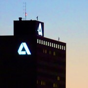 La silhouette de la tour et le « A » allumé sur la façade, à la tombée du jour.