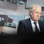 Jean Charest regarde au loin dans la nouvelle Maison de Radio-Canada.