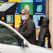 Des passants dans la rue avec un masque pour se protéger de la COVID-19 en Saskatchewan.