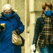 Des gens portant des masques à l'extérieur en hiver, pendant la pandémie de la COVID-19 à Regina, en Saskatchewan.