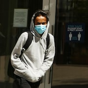 Un homme porte un masque à l'extérieur pendant la pandémie de la COVID-19 à Regina au printemps. 