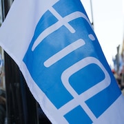 Un drapeau sur lequel est imprimé un logo de la FIQ.