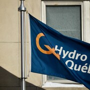 Un drapeau portant le logo d'Hydro-Québec devant la fenêtre d'un édifice.